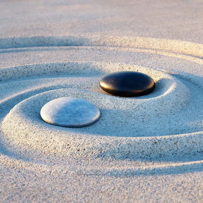 Yin Yang Motive made of stones and lines in the sand cropped 1.webp
